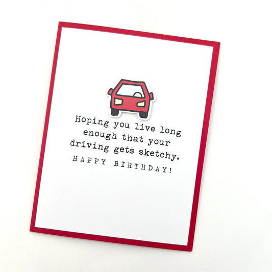 Birthday card with a red car illustration and humorous text on a white background