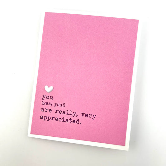Pink card with text and a heart on a white background