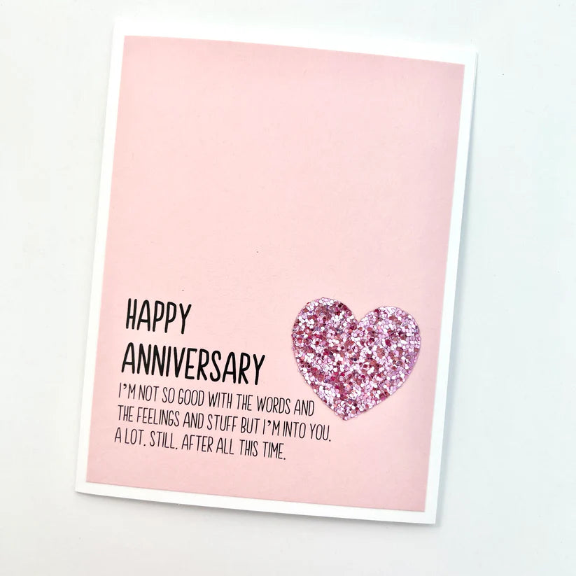 Greeting card with 'Happy Anniversary' message and pink heart on a light pink background