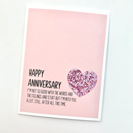 Greeting card with 'Happy Anniversary' message and pink heart on a light pink background